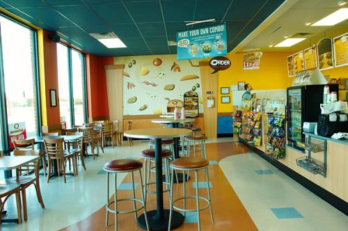 Modern deli with seating and vibrant walls.