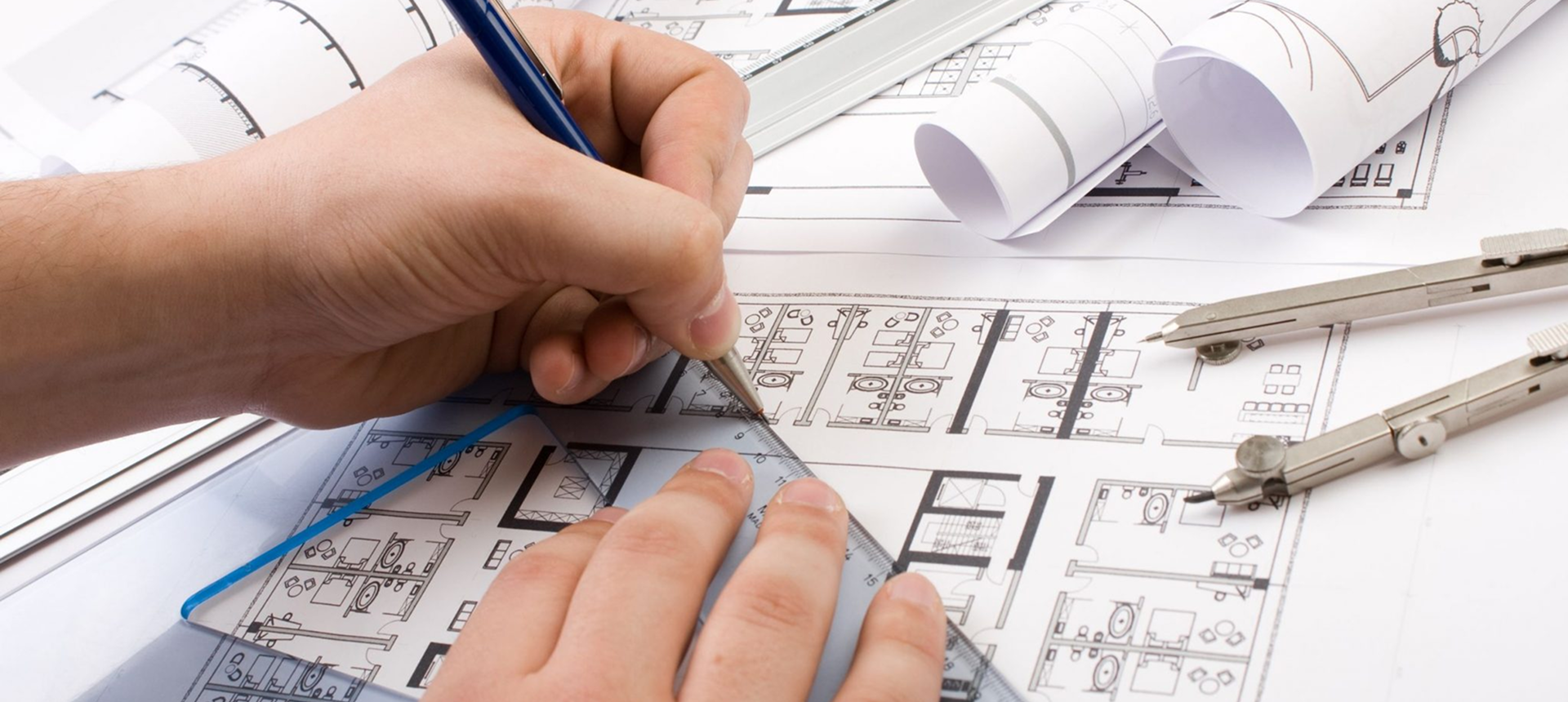 Hands sketching architectural plans on paper